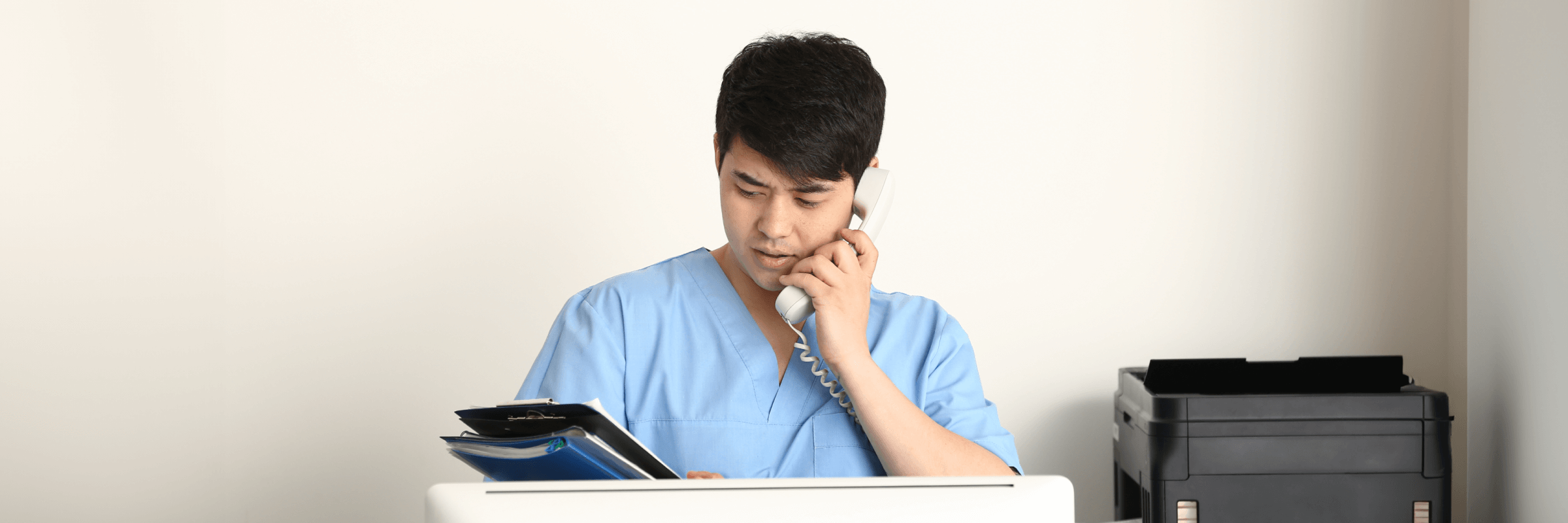Nurse using the telephone and looking at files 