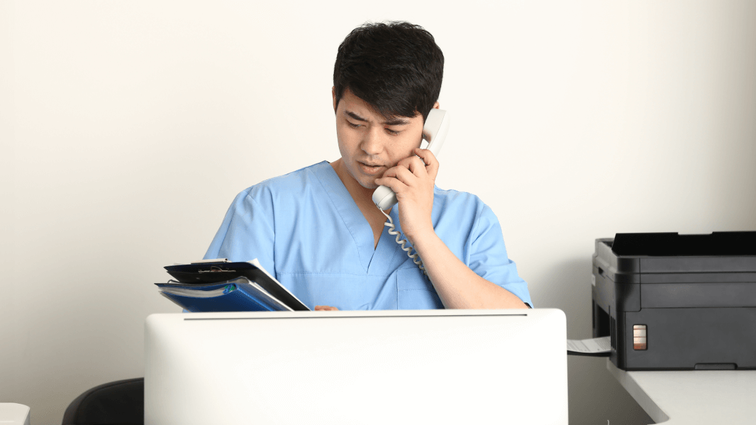 Nurse using the telephone and looking at files 