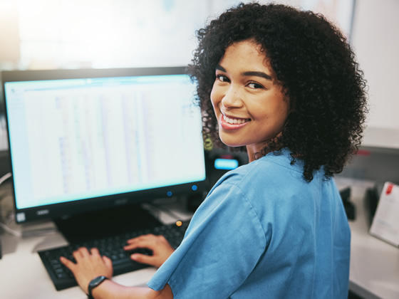 Smiling Nurse on Computer