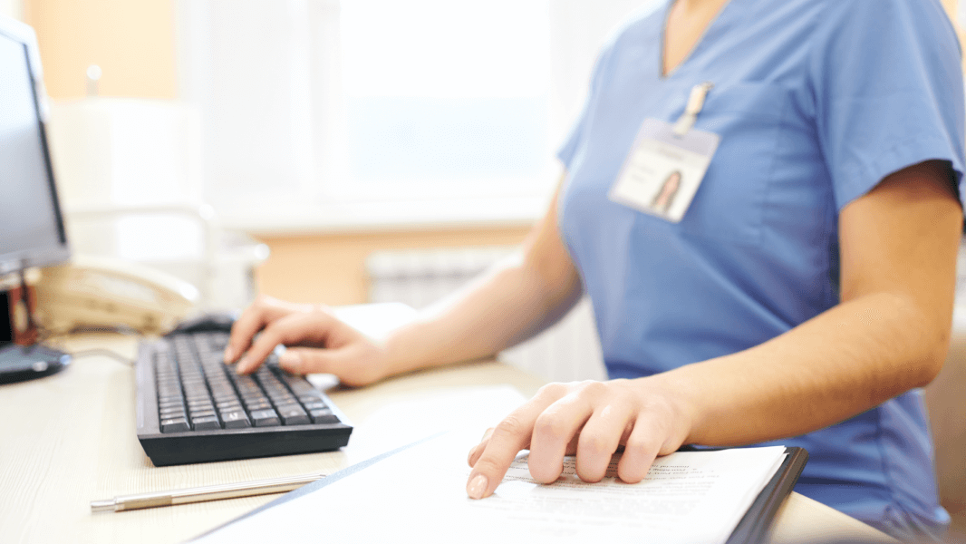 Nurse sitting at desk using computer