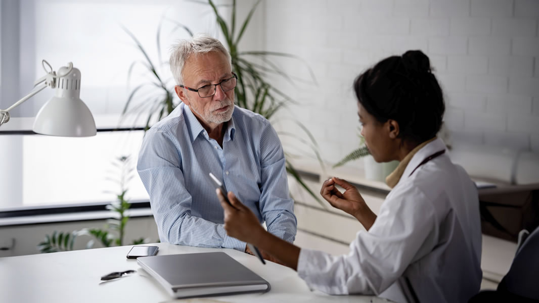 Female healthcare professional talking with an elderly male patient