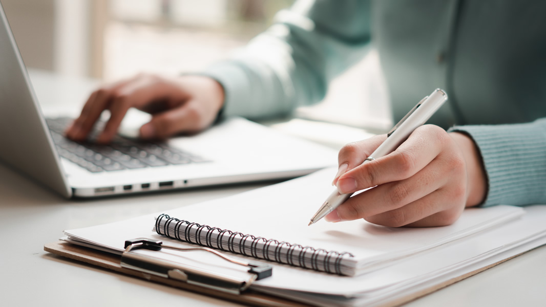 Female with laptop taking notes