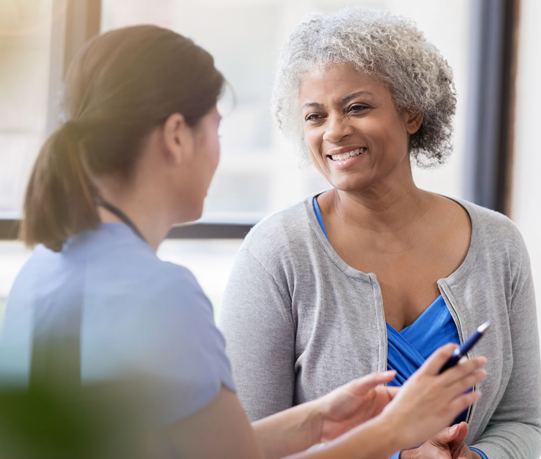 Young nurse and senior patient smile and talk