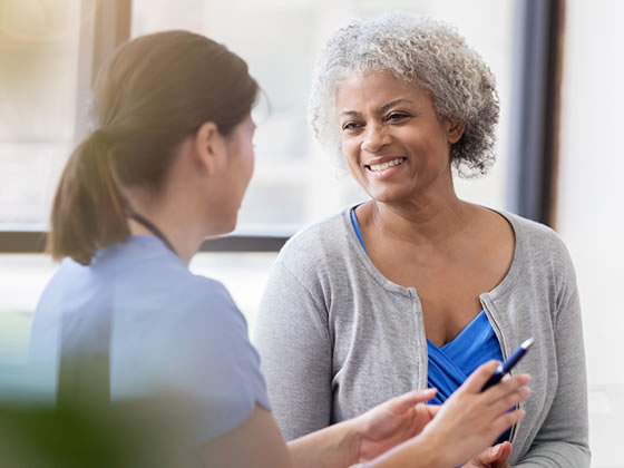 Young nurse and senior patient smile and talk